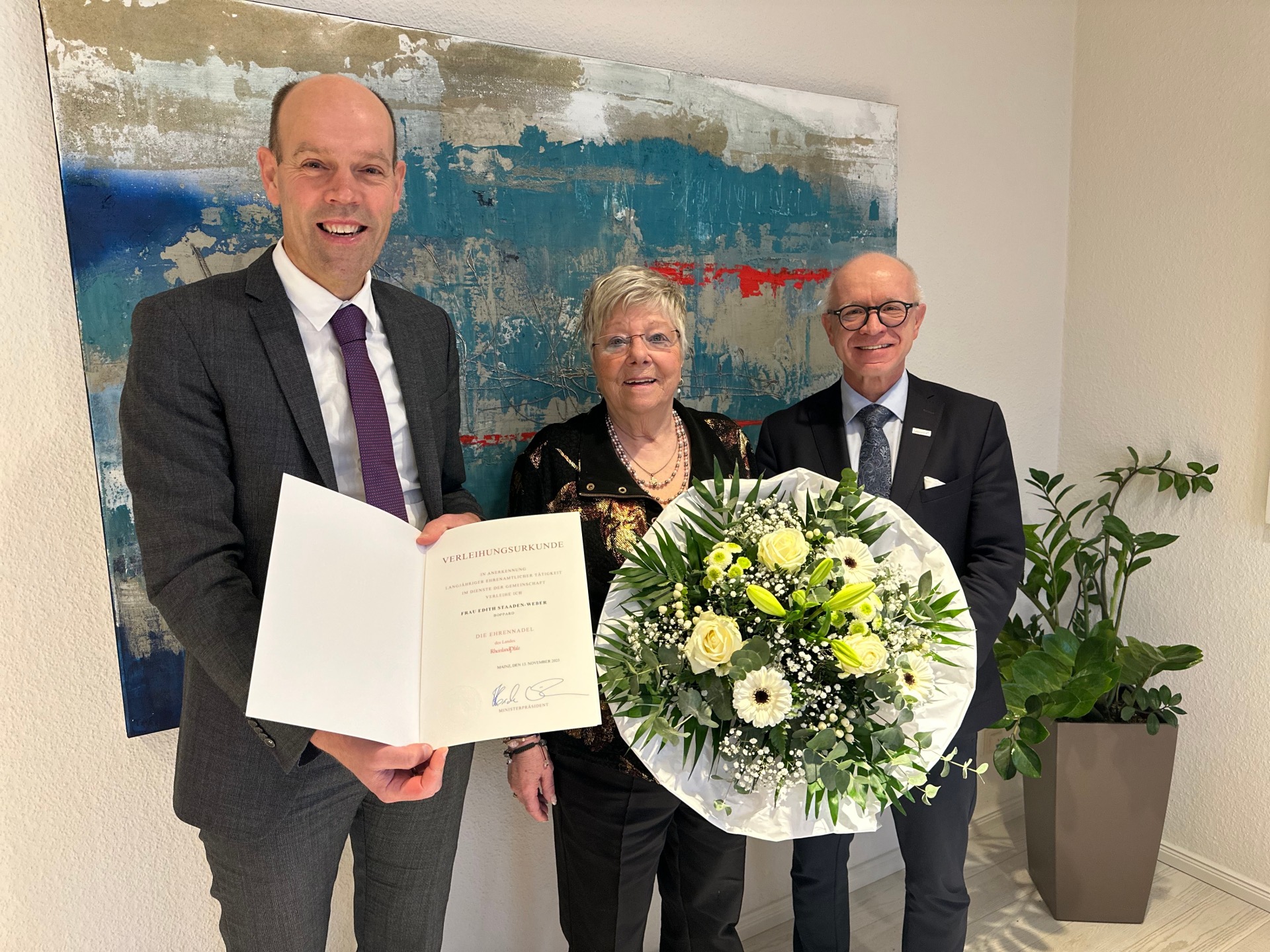 Landrat Volker Boch (links) hat Edith Staaden-Weber im Beisein von  Jörg Haseneier, Bürgermeister der Stadt Boppard, mit der Ehrennadel des Landes ausgezeichnet.