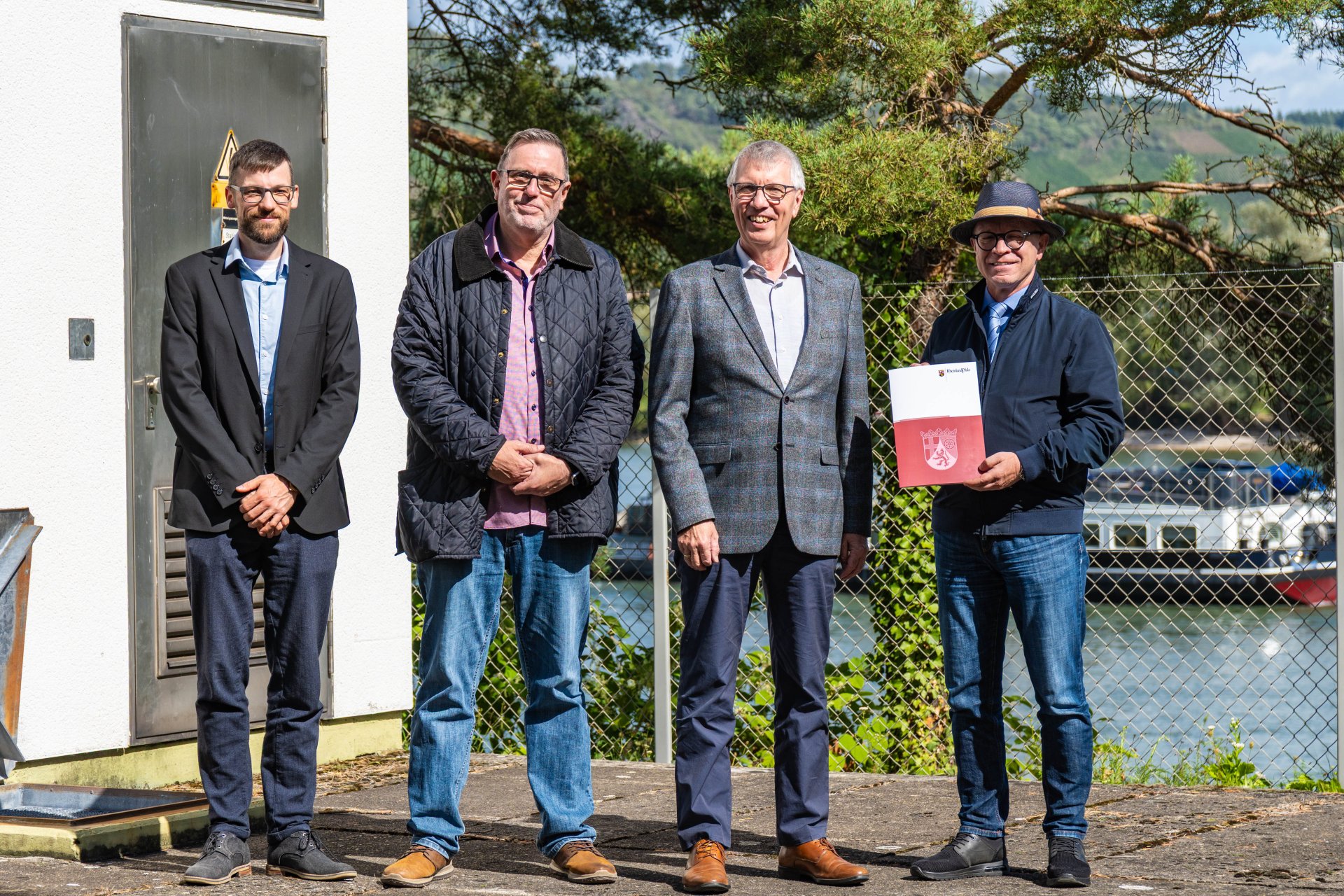 Bei der Bescheidübergabe vor der Pumpstation "Pappelwäldchen" in Boppard (von links): Dominik Nachtsheim, Leiter des Fachbereichs 5 (Eigenbetrieb Kanalwerke, Hoch und Tiefbau) bei der Stadt Boppard, Marc Stimpfl, Werkleiter Eigenbetrieb Kanalwerke der Stadt Boppard, Umwelt- und Klimaschutzstaatssekretär Erwin Manz vom Mainzer Ministerium für Klimaschutz, Umwelt, Energie und Mobilität, und Jörg Haseneier, Bürgermeister der Stadt Boppard. 
