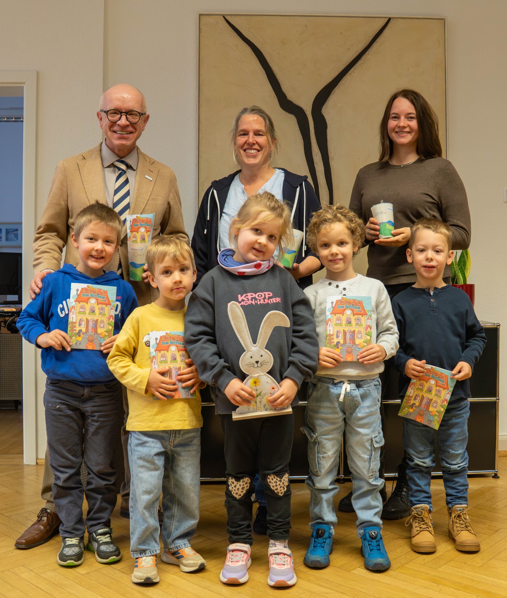 Fünf Kinder aus dem Kinderparlament der Kita „Kleines Abenteuer“ haben gemeinsam mit ihren Erzieherinnen Svenja Härter (hinten, Mitte) und Marijke Petershans (hinten, rechts) die Stadtverwaltung und Bürgermeister Jörg Haseneier (hinten, links) besucht. Mit auf dem Foto ist auch ein dekorativer Hase aus dem Büro des Bürgermeisters – eine kleine Anspielung auf seinen Nachnamen. 