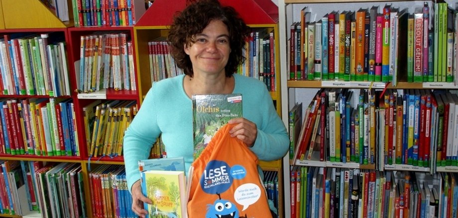 Das Foto zeigt die Leiterin der Stadtbücherei Boppard, wie sie Werbung für den Lesesommer macht.