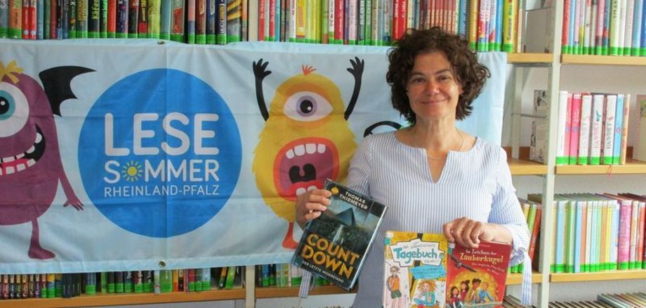 Das Foto zeigt die Leiterin der Stadtbücherei Boppard vor Bücherregalen anlässlich des Lesesommers 2022.
