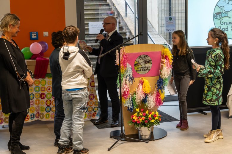 Auf dem Foto: Schulleiterin Barbara Lautwein-Gromes (links) und Bürgermeister Jörg Haseneier mit den vier Kindermoderatorinnen und -moderatoren, die beim Festakt durch das Programm führten.