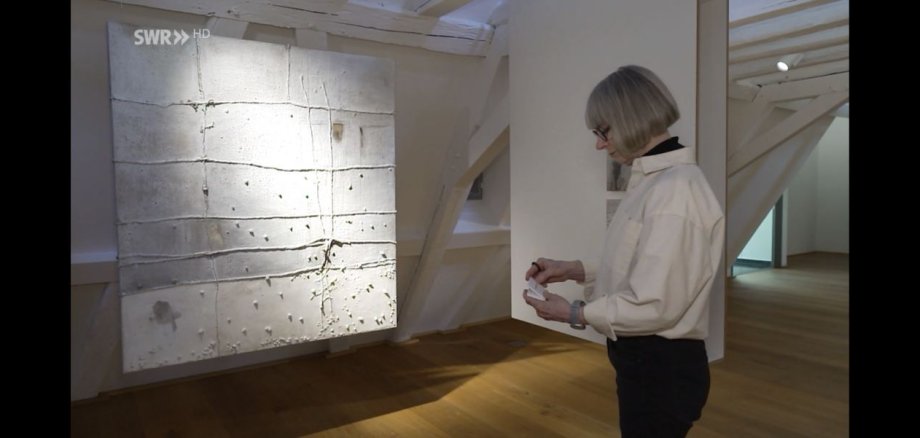 Auf dem Foto ist die Künstlerin Christel Hermann zu sehen, wie sie die Ausstellung im Museum Boppard vorbereitet.