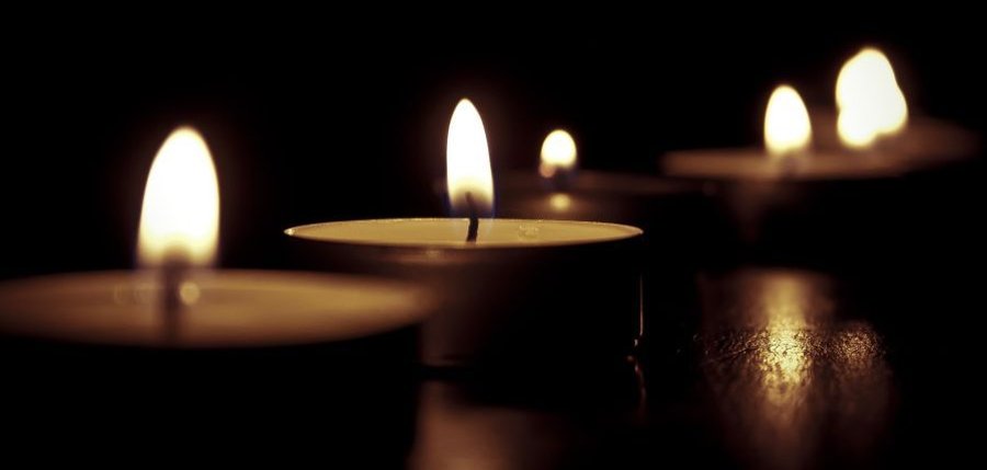 Das Foto zeigt Kerzen vor einem dunklen Hintergrund.