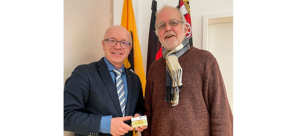 Boppards Bürgermeister Jörg Haseneier (links) überreicht Wilfried Minning die Jubiläums-Ehrenamtskarte. Wilfried Minning unterstützt die Stadt Boppard seit mehr als 30 Jahren als ehrenamtlicher Bachpate.