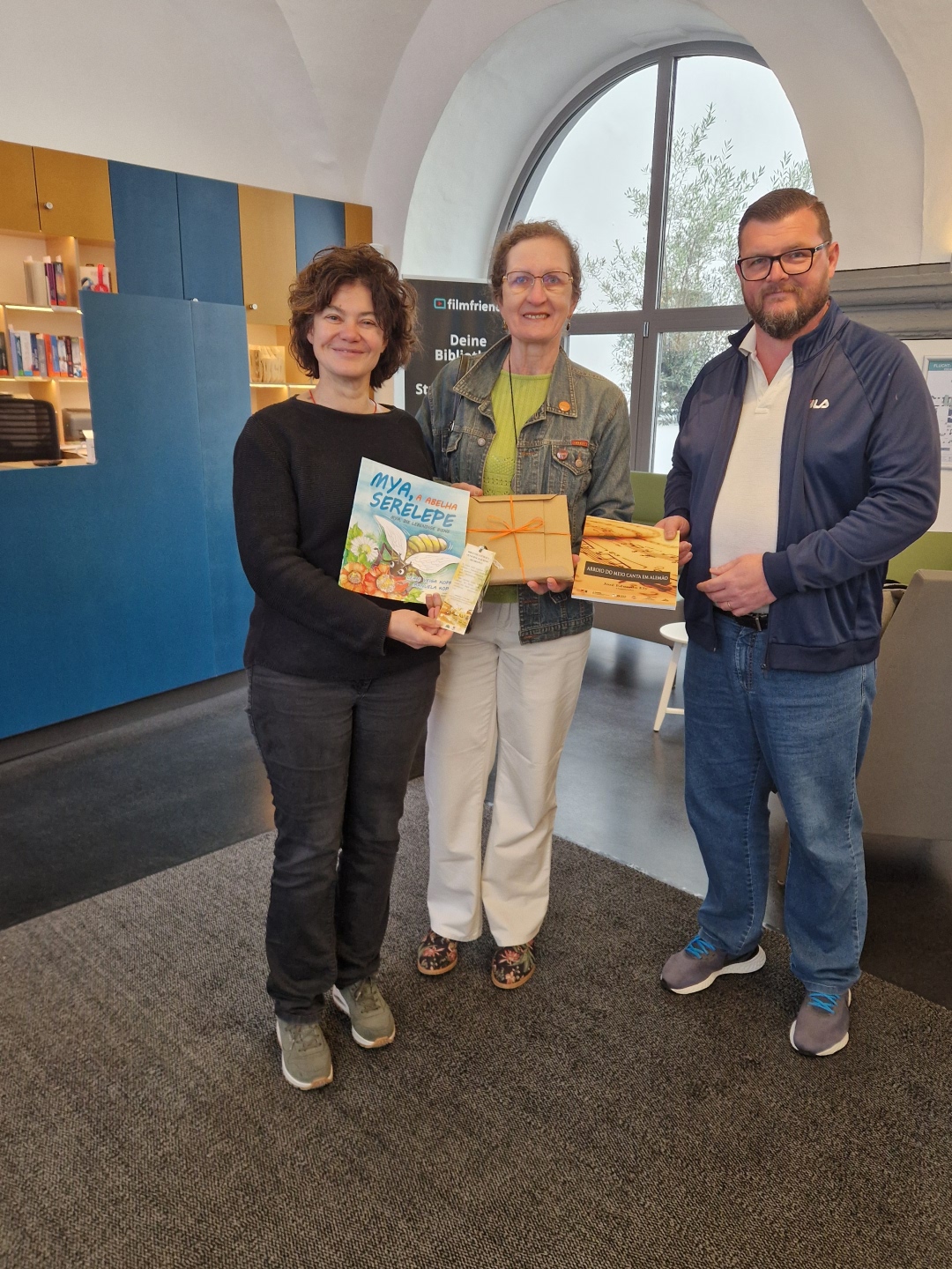 Buchgeschenke aus der Partnerstadt Arroio do Meio für die Stadtbibliothek Boppard. Eneida Führ Kuhn (Mitte) und Eduardo Ely (rechts), beide Mitglieder des brasilianischen Freundeskreises aus Arroio do Meio, überreichen zwei Bücher an die Leiterin der Stadtbibliothek Sonja Weinert.