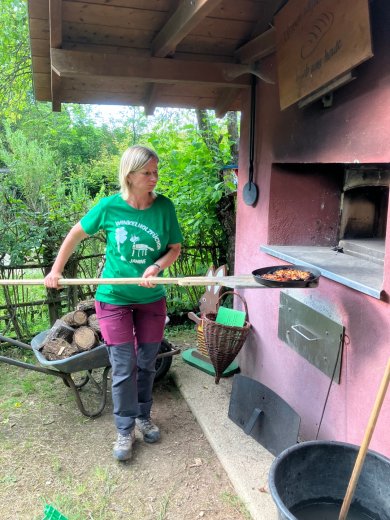 Pizza wird in den Pizzaofen geschoben