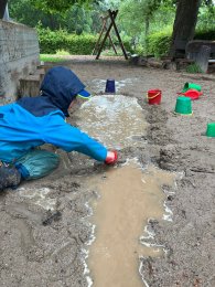 Kind beim spielen mit Schlamm
