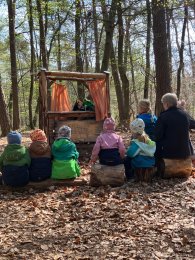 Kinder beim Puppentheater im Wald