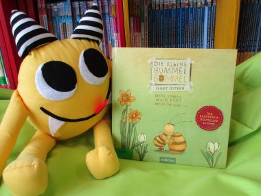 Büchermonster Nibbels begleitet als Maskottchen die Vorlesestunden. Hier zu sehen mit einem Bilderbuch