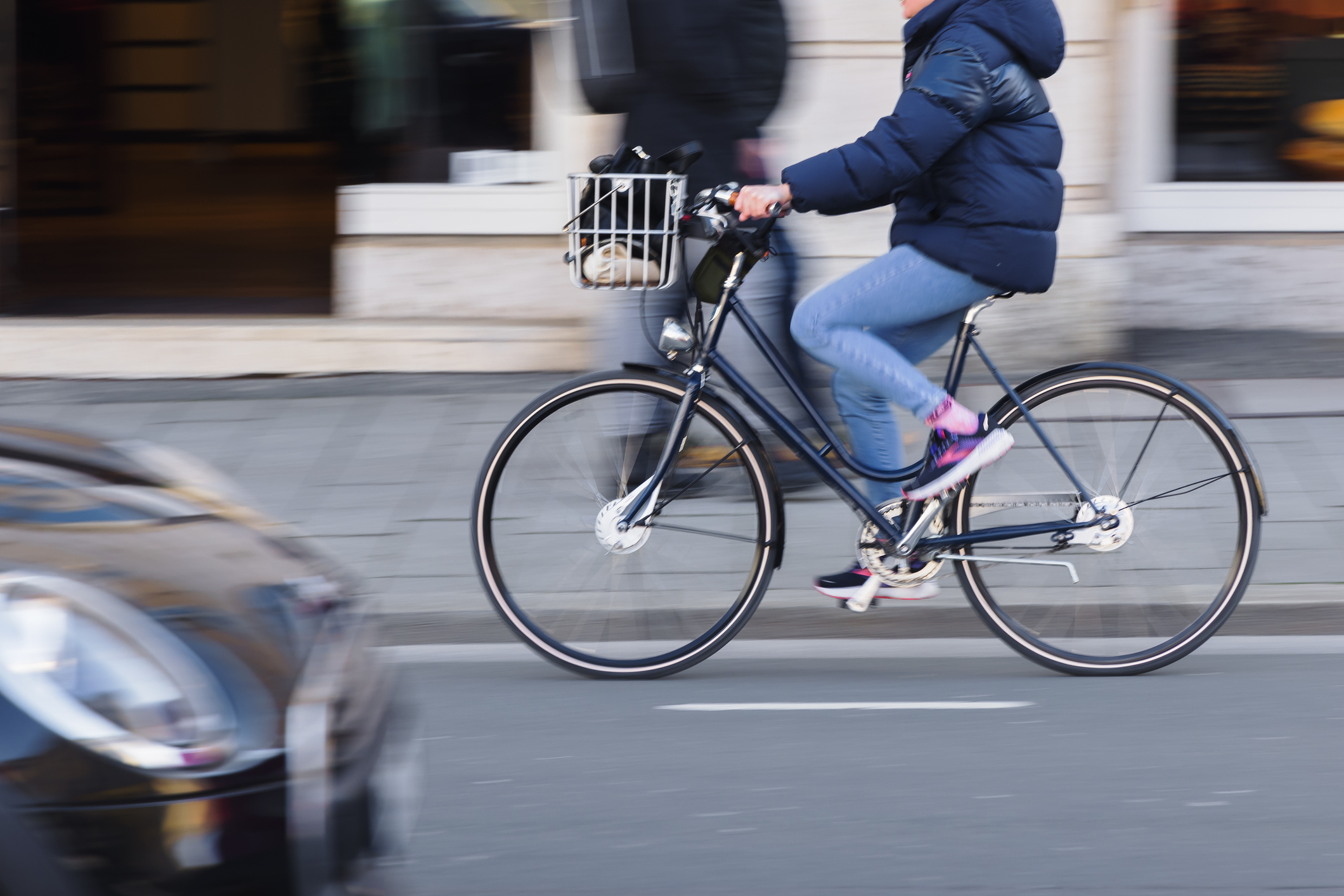 person with a bicycle on the move in city traffic