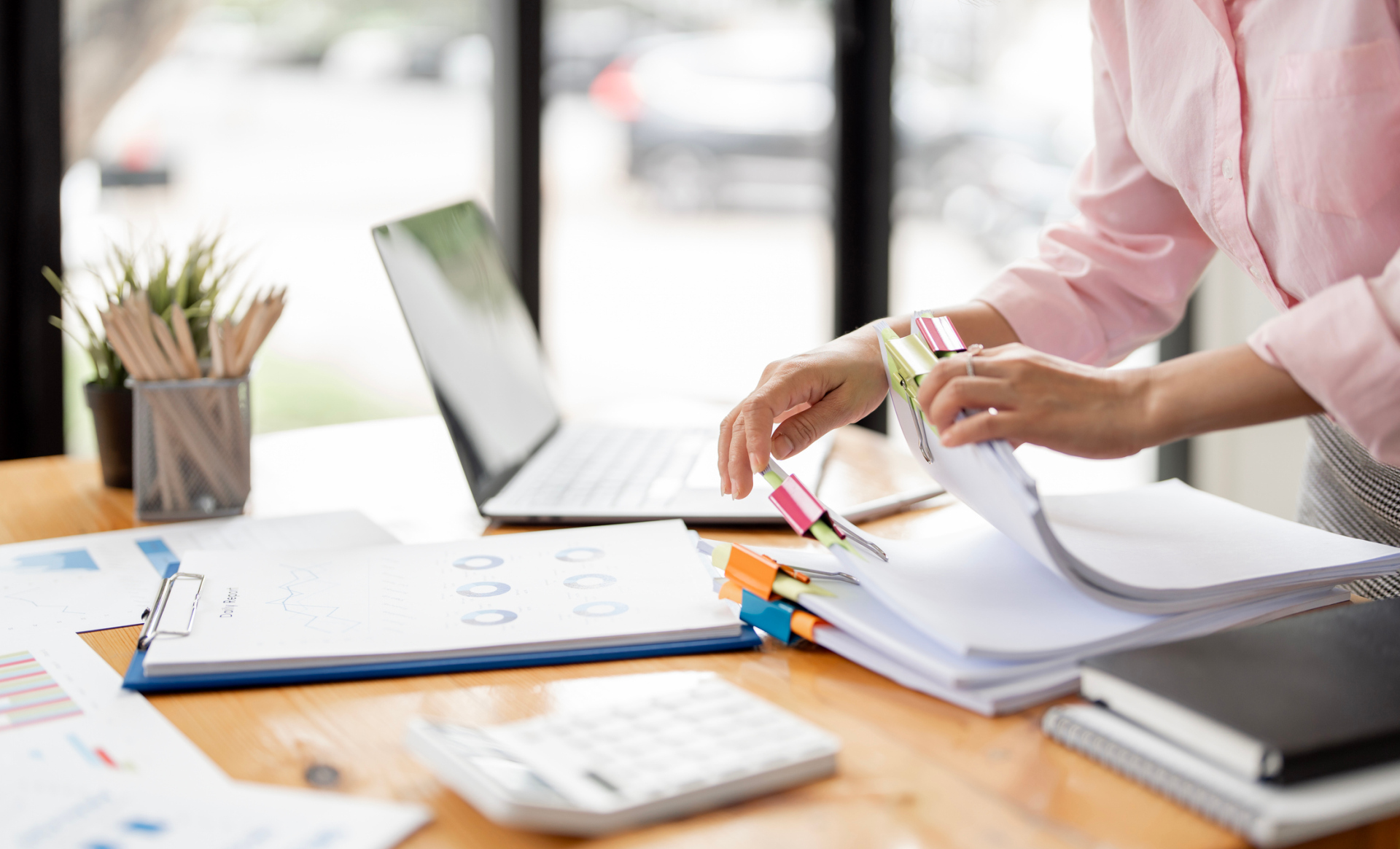 Businesswoman hands working in Stacks of paper files for searching and checking unfinished document achieves on folders papers