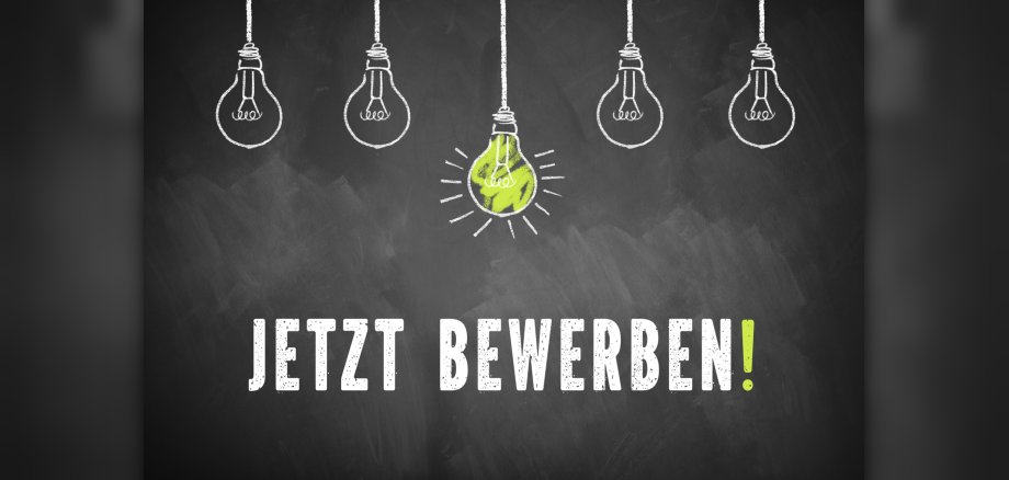 chalk lightbulbs and the message 'Apply Now!' in German on a chalkboard Jetzt bewerben