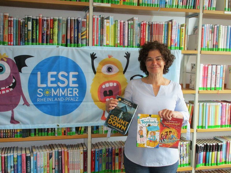 Das Foto zeigt die Leiterin der Stadtbücherei Boppard vor Bücherregalen anlässlich des Lesesommers 2022.