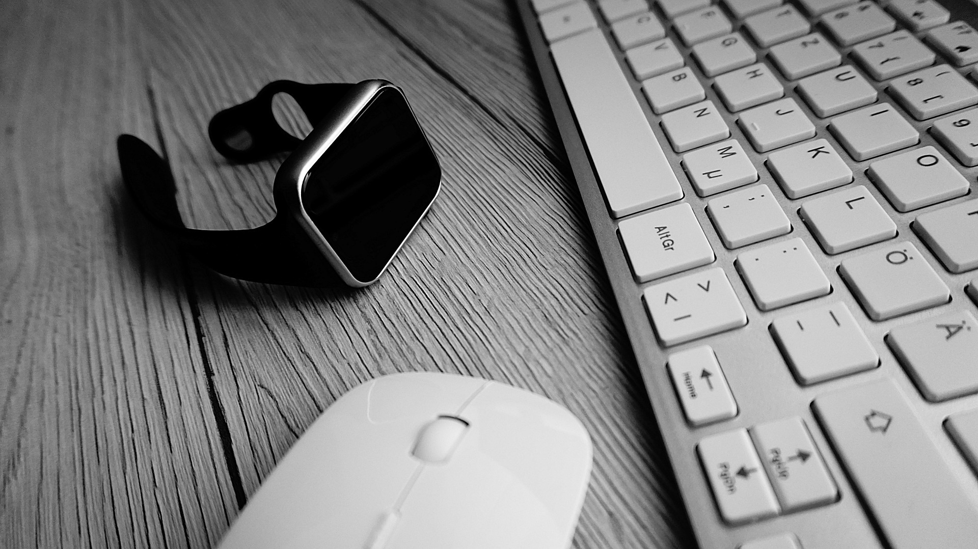Eine Tastatur, eine Maus und eine Smartwatch sind auf dem Foto zu sehen.