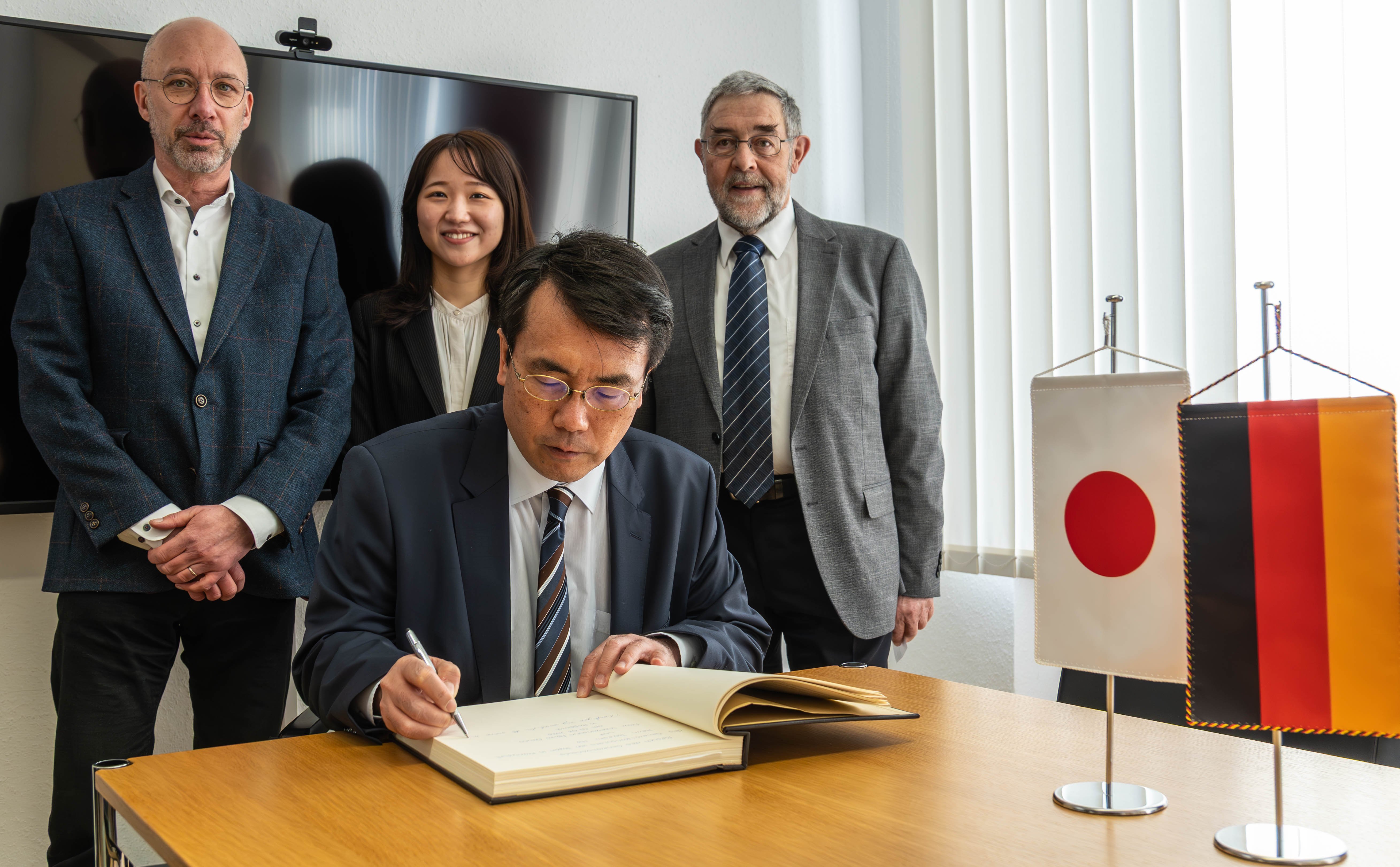 Der japanische Generalkonsul Takeshi Ito (vorne), hier beim Eintrag in das Goldene Buch der Stadt Boppard, und Vizekonsulin Maiko Okuno haben die Stadt Boppard besucht. Empfangen wurden sie vom Ersten Beigeordneten der Stadt Boppard, Helmut Zindorf (rechts), und vom Vorsitzenden des Freundeskreises Ome Boppard, Alfred Roos.