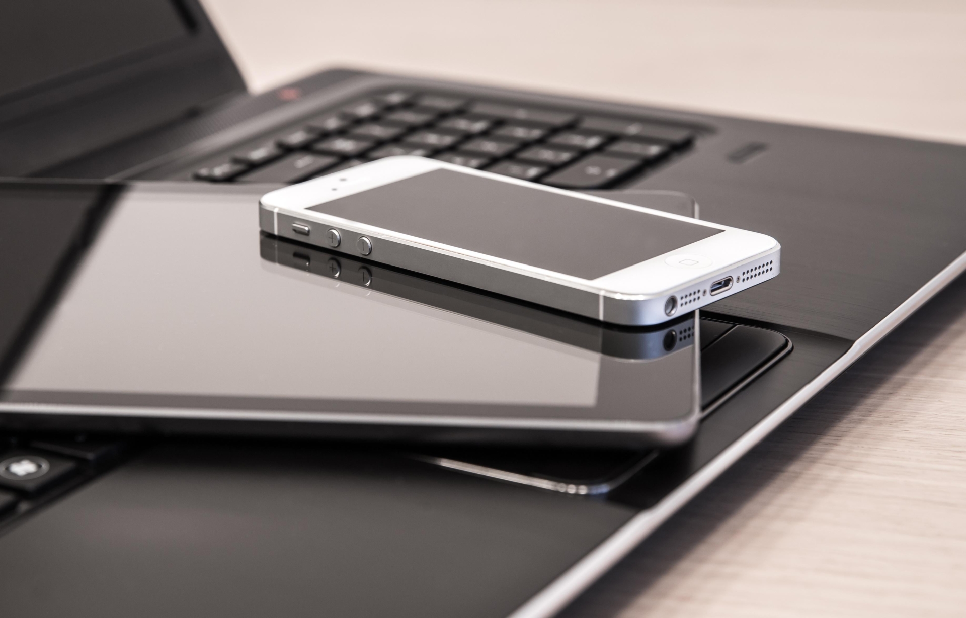 Digitale Geräte, wie Laptop und Handy sind abgebildet.