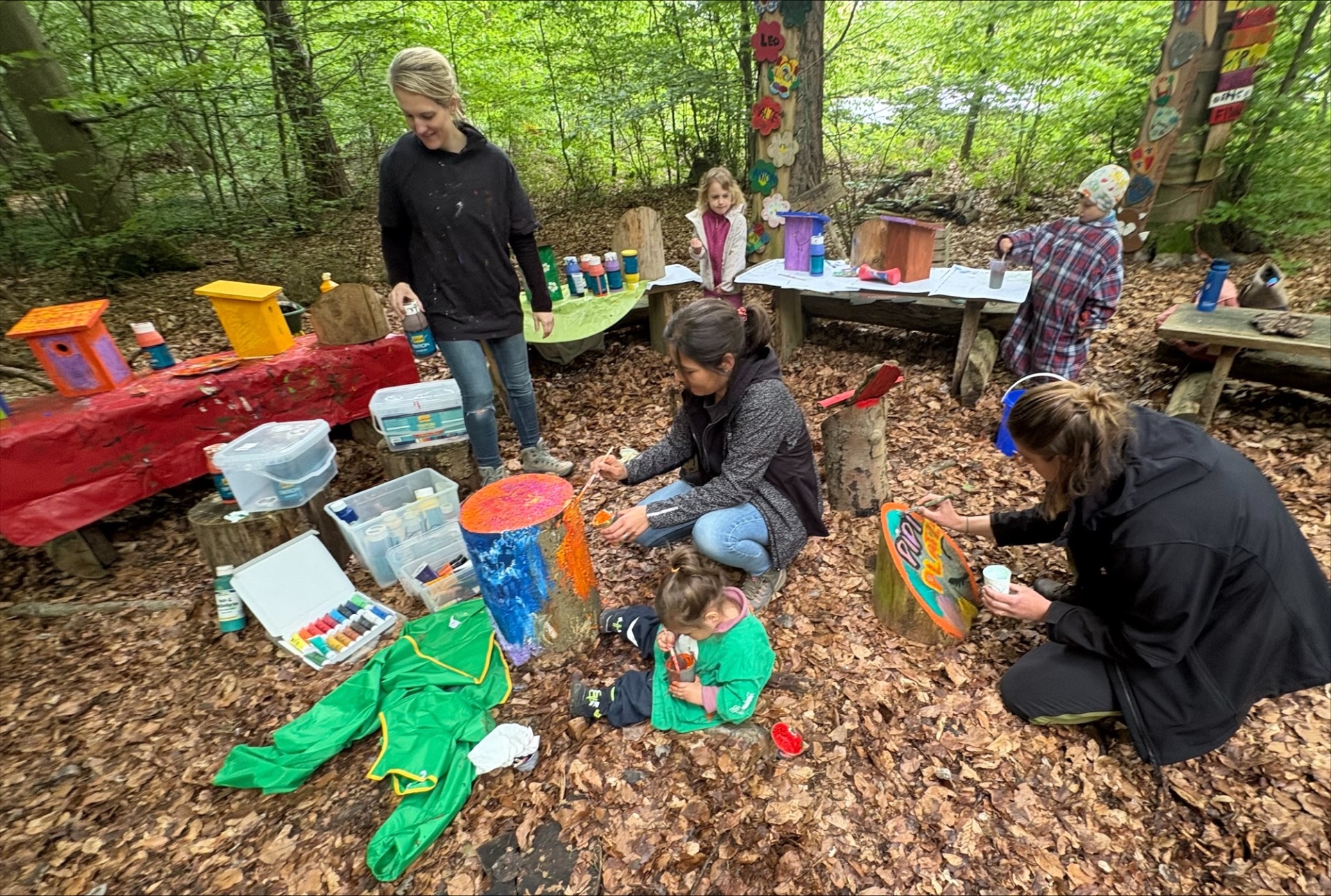 Kinder und Erwachsene bemalten gemeinsam farbenfrohe Schilder und Dekorationen für die verschiedenen Waldplätze und verwandelten einfache Vogelhäuschen in kleine Kunstwerke. 