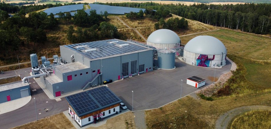 Auch die Rhein-Hnsrück-Entsorgung (RHE) beteiligt sich an dem innovativen Vorhaben, eine Kreisenergiegesellschaft zu gründen. Auf dem Foto: Die hochmoderne Biogut-Vergärungsanlage der RHE in Kirchberg, die den gesamten Bioabfall aus dem Rhein-Hunsrück-Kreis verwertet. Aus den jährlich anfallenden 13.000 Tonnen Bioabfall des Rhein-Hunsrück-Kreises wird hochwertiger organischer Flüssigdünger gewonnen, der in der regionalen Landwirtschaft eingesetzt wird. Darüber hinaus erzeugt die Biogut-Vergärungsanlage mithilfe eines Blockheizkraftwerks jährlich rund 4 Millionen Kilowattstunden Strom aus dem während des Vergärungsprozesses entstehenden Biogas.