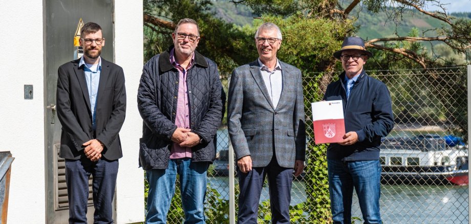 Bei der Bescheidübergabe vor der Pumpstation "Pappelwäldchen" in Boppard (von links): Dominik Nachtsheim, Leiter des Fachbereichs 5 (Eigenbetrieb Kanalwerke, Hoch und Tiefbau) bei der Stadt Boppard, Marc Stimpfl, Werkleiter Eigenbetrieb Kanalwerke der Stadt Boppard, Umwelt- und Klimaschutzstaatssekretär Erwin Manz vom Mainzer Ministerium für Klimaschutz, Umwelt, Energie und Mobilität, und Jörg Haseneier, Bürgermeister der Stadt Boppard. 